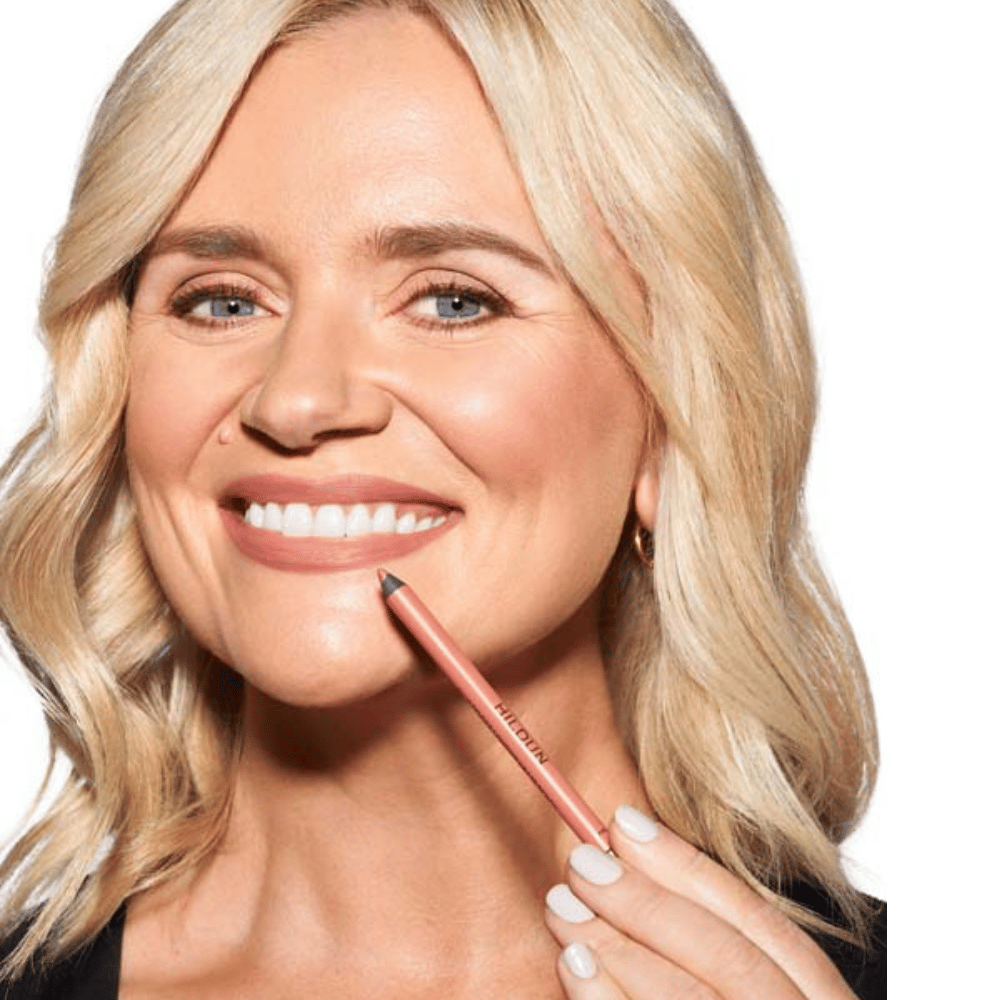 Woman model smiling holding Hildun Beauty lip liner beside her mouth
